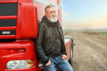 Portrait of mature driver at modern truck outdoors. Space for text